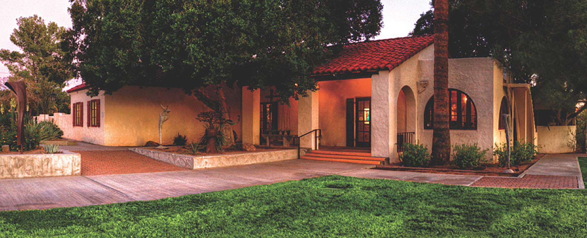 A house with a red roof and grass on the ground.